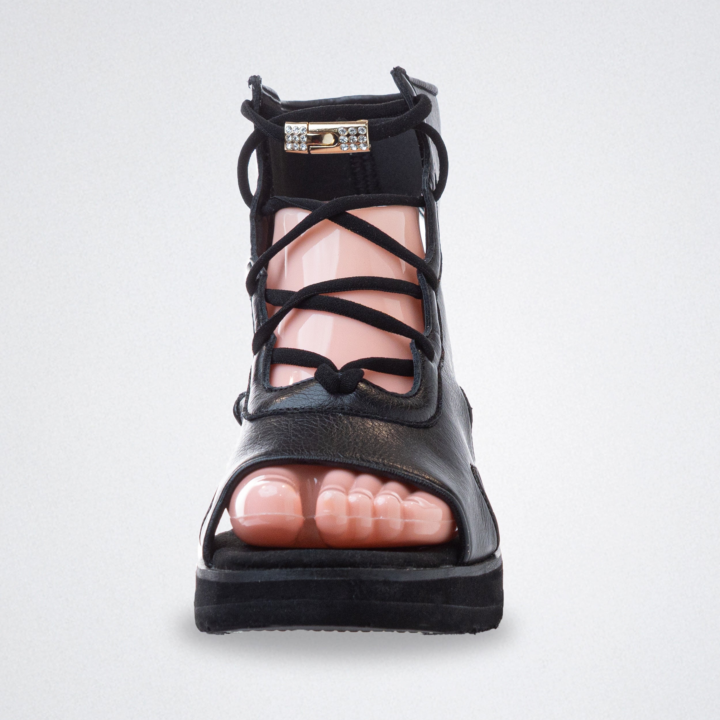 Black strappy sandal on a light gray background